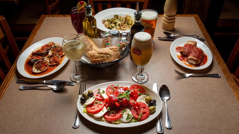 Several plated entrees with focus on fresh mozzarella salad